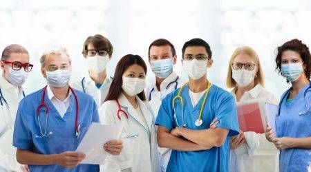 FamVeld/shutterstock.com Mehrere Ärzte und Ärztinnen verschiedenen Alters stehen zusammen. s