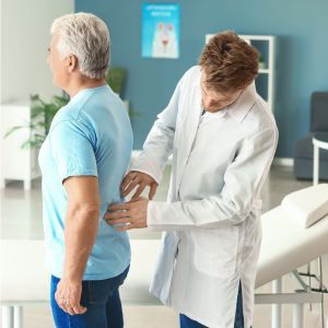 Urologe untersucht Patienten am Rücken